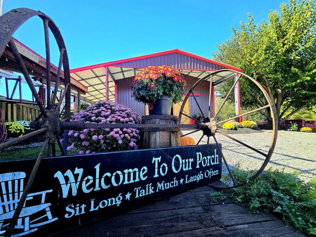 Seasonal flowers and vintage wagon wheels at The RiverBarn entrance