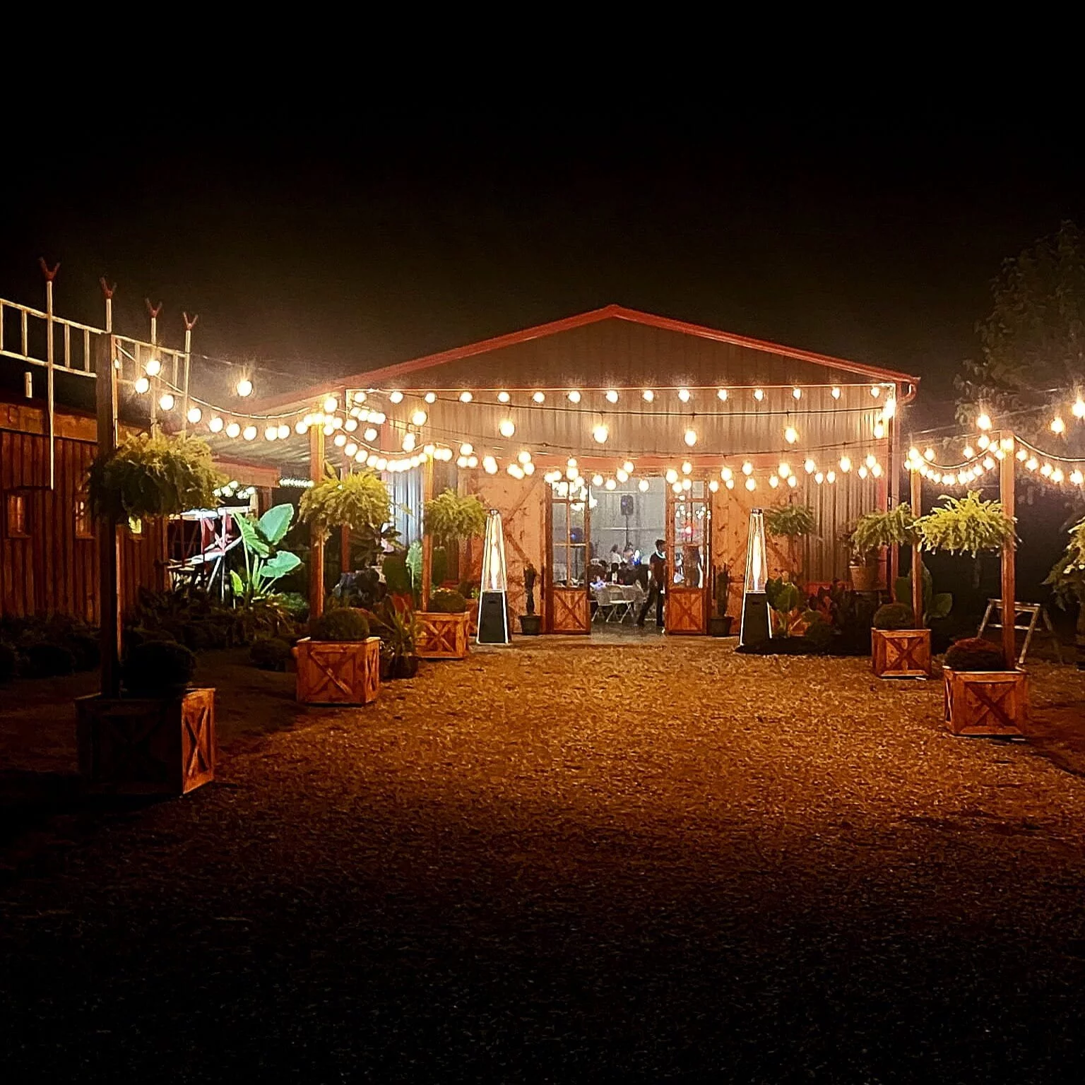 The RiverBarn exterior glowing with string lights during an evening event