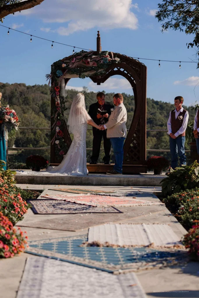 Outdoor ceremony under the RiverBarn wooden arch overlooking the river